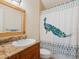 Bathroom featuring a vanity with granite countertop, patterned shower curtain and decorative mirror at 3648 Beneva Oaks Blvd, Sarasota, FL 34238