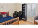 Bedroom with wooden bed frame, desk setup, and storage shelves at 3648 Beneva Oaks Blvd, Sarasota, FL 34238