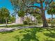 Well-manicured lawn leads to home with attached two-car garage and lush landscaping and mature trees at 3648 Beneva Oaks Blvd, Sarasota, FL 34238