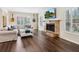 Bright living room features hardwood floors, cozy seating, and a stone fireplace with a mounted TV at 3648 Beneva Oaks Blvd, Sarasota, FL 34238