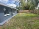 A spacious backyard with a mix of grass and shaded areas surrounded by a wooden fence at 3826 Clover Ln, Sarasota, FL 34233
