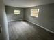 A spacious, neutrally painted bedroom features wood-look tile flooring and ample natural light from the large window at 3826 Clover Ln, Sarasota, FL 34233