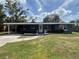 Charming single story home featuring a covered entrance, manicured shrubs, and a well kept lawn at 3826 Clover Ln, Sarasota, FL 34233