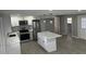 Bright kitchen features new stainless appliances, quartz counters, a stylish tile backsplash and wood-look tile flooring at 3826 Clover Ln, Sarasota, FL 34233