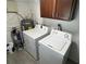 Laundry area with side by side washer and dryer and overhead storage cabinets at 3826 Clover Ln, Sarasota, FL 34233