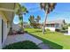 Charming backyard featuring a stamped concrete patio, lush lawn, and mature palm trees at 390 301 W Blvd # 13A, Bradenton, FL 34205