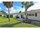 Lush backyard offers a relaxing patio area surrounded by mature landscaping and blue skies at 390 301 W Blvd # 13A, Bradenton, FL 34205