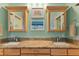 Bathroom featuring double sinks, framed mirrors, and neutral color scheme at 3924 Riverview Blvd, Bradenton, FL 34209