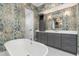 A elegant bathroom features a soaking tub, a vanity with sink, custom cabinets and designer wallpaper at 412 Pheasant Way, Sarasota, FL 34236