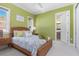 Inviting bedroom offers a cozy wicker bed, relaxing green walls, and access to an ensuite bathroom at 412 Pheasant Way, Sarasota, FL 34236