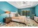 Bright primary bedroom featuring a king bed, designer bedside table lamps, and access to the screened in pool and lanai at 412 Pheasant Way, Sarasota, FL 34236