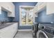 Well-equipped laundry room features modern washer and dryer, built-in cabinets, and a bright window at 412 Pheasant Way, Sarasota, FL 34236