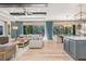 Open concept living and kitchen area with hardwood floors, modern furniture, and ample sunlight at 412 Pheasant Way, Sarasota, FL 34236