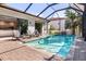 Private screened-in pool area surrounded by lounge chairs and lush landscaping, perfect for relaxation at 412 Pheasant Way, Sarasota, FL 34236