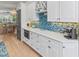 Bright kitchen with white cabinets, wine storage, and a colorful tile backsplash at 449 Canal Rd # 449, Sarasota, FL 34242