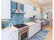 Bright kitchen featuring stainless steel appliances, a hood, and a blue tile backsplash at 449 Canal Rd # 449, Sarasota, FL 34242