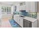 Bright, white kitchen features stainless steel appliances, tile backsplash, and window at 449 Canal Rd # 449, Sarasota, FL 34242