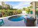 A kidney-shaped pool with well-kept greenery and blue lounge chairs at 449 Canal Rd # 449, Sarasota, FL 34242