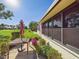 Back patio with wooden table and umbrella overlooking beautiful lawn and golf course at 4534 La Jolla Dr, Bradenton, FL 34210