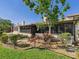 Backyard with shrubs, gravel, grass, and plants, and view of the sunroom with screened windows at 4534 La Jolla Dr, Bradenton, FL 34210