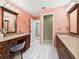 Bathroom featuring granite countertops, wood cabinets, white tile floor, and vanity with chair at 4534 La Jolla Dr, Bradenton, FL 34210