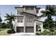 Modern two-story home with a two-car garage, balcony, and tropical landscaping at 4903 Commonwealth Dr, Sarasota, FL 34242