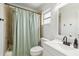 Updated bathroom featuring tiled walls, shower with a green curtain, a white sink, and modern fixtures at 5020 Live Oak Cir, Bradenton, FL 34207