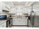 Well-lit kitchen with stainless steel appliances, modern fixtures, and white cabinetry at 5020 Live Oak Cir, Bradenton, FL 34207
