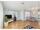 Light and airy living room with hardwood floors, TV, and view into the dining area at 5020 Live Oak Cir, Bradenton, FL 34207