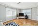 Spacious living room with hardwood floors, TV, and two bright windows at 5020 Live Oak Cir, Bradenton, FL 34207