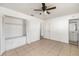 This bedroom features tile flooring, a ceiling fan, closet with bench, and ensuite bathroom at 5072 Vinson Way, Sarasota, FL 34232