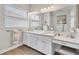 Bright bathroom featuring double sinks, vanity, makeup station, and a large mirror at 525 Maraviya Blvd, Nokomis, FL 34275