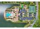 Overhead view showcasing a community pool, tennis courts, clubhouse, and ample parking surrounded by tropical landscaping at 525 Maraviya Blvd, Nokomis, FL 34275