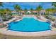 An inviting zero-entry community pool with ample seating surrounded by palm trees and lush landscaping at 525 Maraviya Blvd, Nokomis, FL 34275
