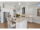 Spacious white kitchen featuring stainless steel appliances, an island with seating, and tile backsplash at 525 Maraviya Blvd, Nokomis, FL 34275