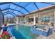 Beautiful screened pool and spa with an outdoor lounge and dining area; water features and view of the house at 525 Maraviya Blvd, Nokomis, FL 34275