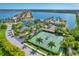 Aerial perspective of tennis courts, community buildings, palm trees, and manicured landscaping near the lake at 525 Maraviya Blvd, Nokomis, FL 34275