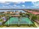 Aerial image of community tennis courts next to lakefront homes, surrounded by palm trees and manicured landscaping at 525 Maraviya Blvd, Nokomis, FL 34275