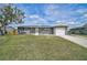 Single-story home featuring a garage and an open front lawn, complete with sunny skies at 555 Oxford Dr, Venice, FL 34293