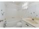 Neat bathroom with a tub, marble-patterned walls, and a window for natural light at 5571 Riverbluff Cir # V1, Sarasota, FL 34231