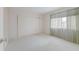 Simple bedroom with a window and sliding closet doors, offering ample storage space at 5571 Riverbluff Cir # V1, Sarasota, FL 34231