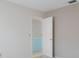 Hallway leading to a bathroom featuring a plain wall and white trim, creating a simple aesthetic at 5571 Riverbluff Cir # V1, Sarasota, FL 34231