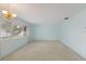 Spacious living room with carpet floors, light blue walls, and a window with natural light at 5571 Riverbluff Cir # V1, Sarasota, FL 34231