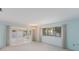 Bright living room with aqua walls, chandelier, and sunroom access for enhanced natural light at 5571 Riverbluff Cir # V1, Sarasota, FL 34231