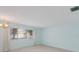 Bright living room featuring carpeted floors, light blue walls, and a large window at 5571 Riverbluff Cir # V1, Sarasota, FL 34231