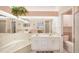 Well-lit bathroom features a double sink vanity, bathtub, and a seamless glass shower for modern convenience at 5608 Country Club Way # 5608, Sarasota, FL 34243