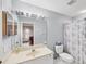 Clean bathroom with a neutral color palette, large mirror, and shower-tub combo at 5608 Country Club Way # 5608, Sarasota, FL 34243