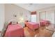 Charming bedroom featuring two beds, sliding mirror closet doors, and coordinated decor for a cozy retreat at 5608 Country Club Way # 5608, Sarasota, FL 34243