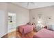 Bedroom with two beds, offering a view into the bathroom, ceiling fan, and coordinated decor for a comfortable stay at 5608 Country Club Way # 5608, Sarasota, FL 34243