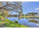 Scenic view of the tranquil pond reflecting the surrounding trees and clear blue sky at 5608 Country Club Way # 5608, Sarasota, FL 34243